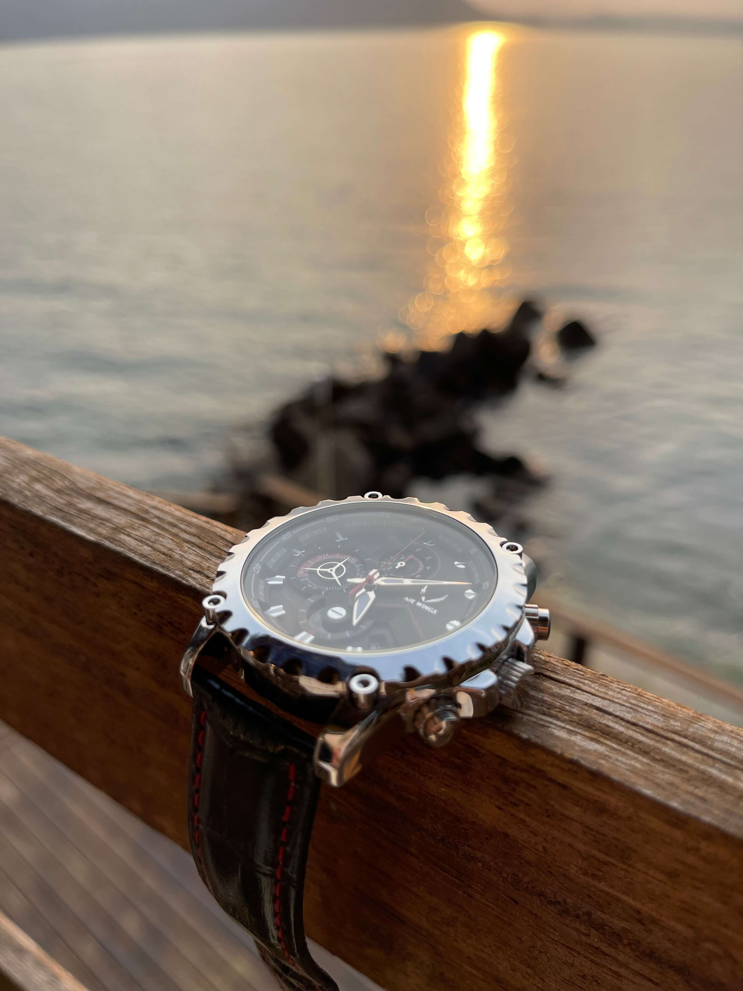 Air Wings Ace - Silver/Black watch on wooden railing with sunset over water, showcasing minimalistic pilot watches perth.